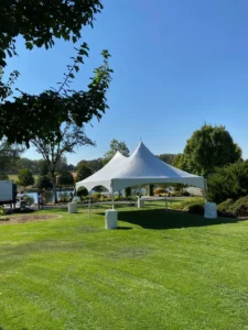 A white tent in the middle of a field.