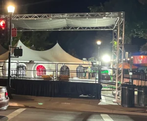 A stage with lights and tents on the side of it.