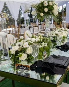 A table with many flowers and glasses on it