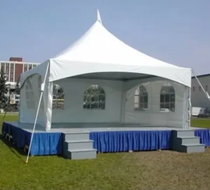 A white tent with blue skirt and blue curtains.
