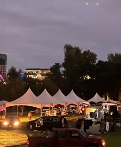 A group of people standing around tents at night.