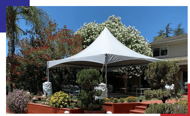 A white tent in the middle of a garden.